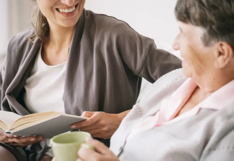 A hospice volunteer reads to a patient in Portland, OR