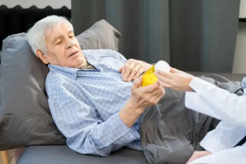 A man in hospice takes his pain medication in Portland, OR