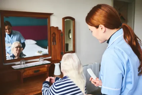 A caretaker combs a hospice patient’s hair in Portland, OR