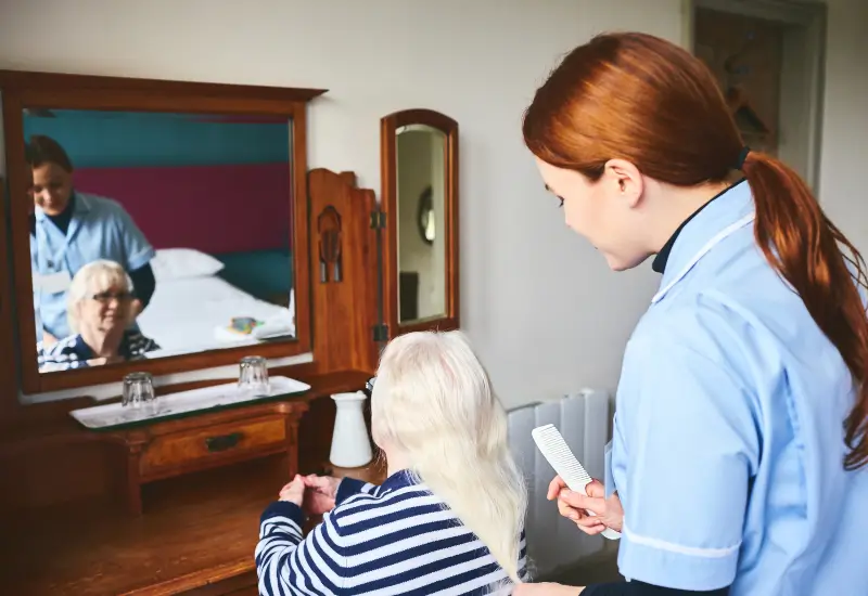 A caretaker combs a hospice patient’s hair in Portland, OR